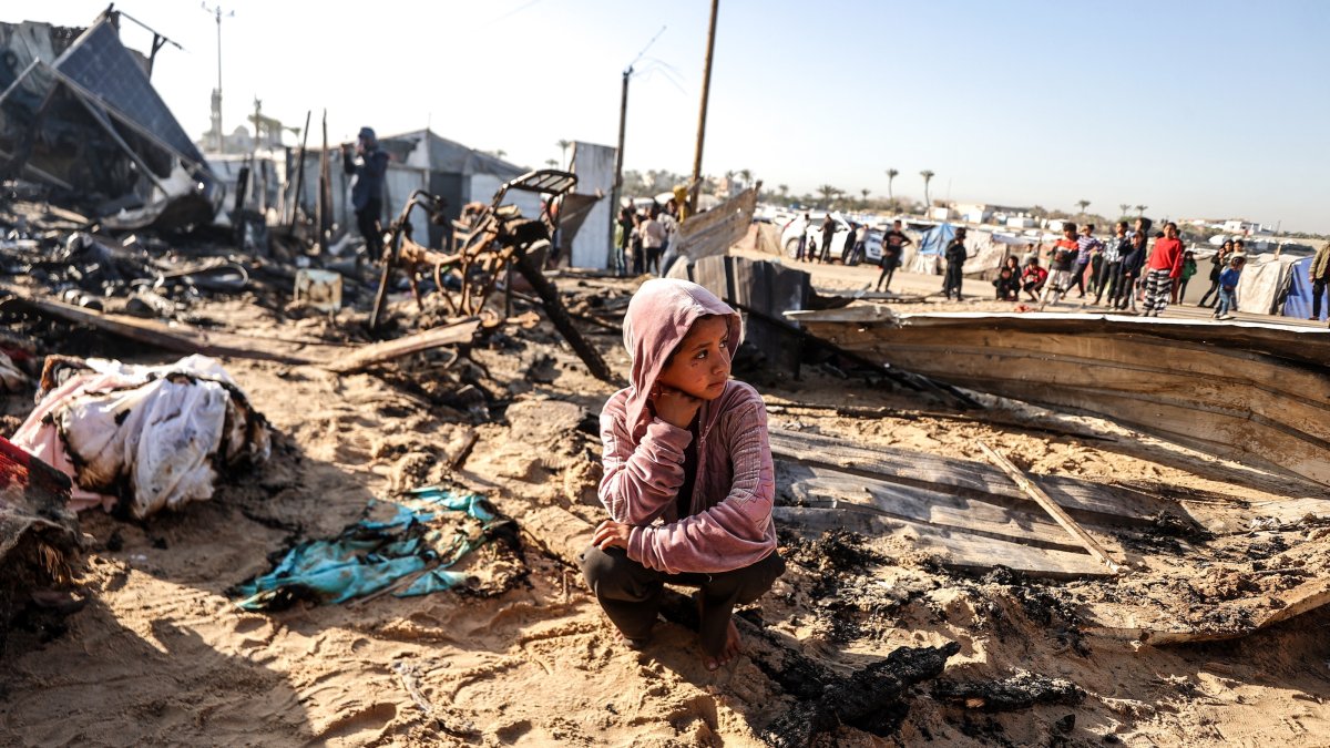 A Palestinian girl sits amid burned-out tents after an Israeli airstrike in Khan Younis, southern Gaza, Palestine, April 17, 2025. (AA Photo)