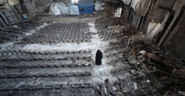Displaced Palestinian Mervat al-Bassiouny, whose leg was amputated due to an Israeli strike, views the damage while using crutches as she shelters inside a building at the Islamic University of Gaza, from where she graduated and which was hit in previous Israeli strikes, Gaza City, Palestine,  April 11, 2025. (Reuters Photo)
