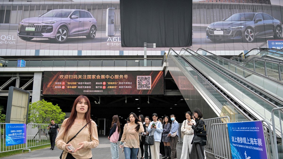 People look on outside the National Exhibition and Convention Center, venue for the upcoming 21st Shanghai International Automobile Industry Exhibition, Shanghai, China, April 21, 2025. (AFP Photo)
