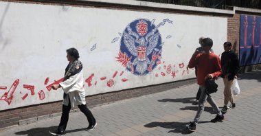People walk past an anti-U.S. mural on a street in Tehran, Iran, April 19, 2025. (Reuters Photo)