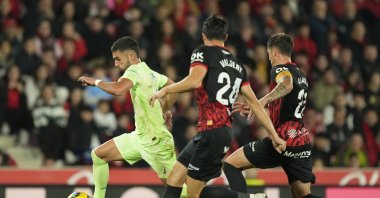 Barcelona&#039;s Ferran Torres (L) is chased by Mallorca&#039;s Martin Valjent (C) and Antonio Raillo during a La Liga match at the Son Moix stadium, Palma de Mallorca, Spain, Dec. 3, 2024. (AP Photo)