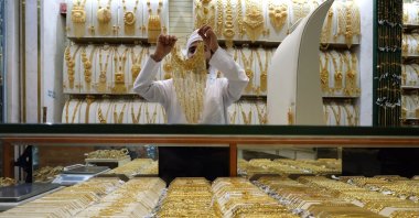 A shop exhibitor shows a gold ornament to a customer at a jewellery shop inside the gold market in Dubai, United Arab Emirates (UAE), April 15, 2025. (EPA Photo)