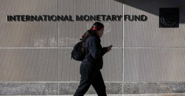 A woman walks past the International Monetary Fund (IMF) ahead of the International Monetary Fund/World Bank Spring Meetings in Washington, D.C., April 17, 2025. (AFP Photo)