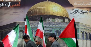 Men carry the Iranian and the Palestinian flags as Iranians attend a rally marking Al-Quds Day (Jerusalem), a commemorative day held annually on the last Friday of the Muslim fasting month of Ramadan, Tehran, Iran, March 28, 2025.  (AFP Photo)
