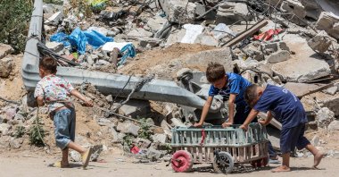 A boy pulls as other boys push a cart past the rubble of a destroyed building in Gaza City, Gaza, Palestine, April 21, 2025. (AFP Photo)