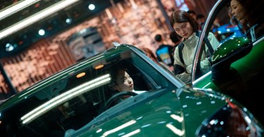 A woman sits in a Cayenne model vehicle on display in the Porsche booth during the Auto Show, Shanghai, China, April 23, 2025. (EPA Photo)