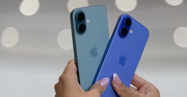 An attendee holds two iPhones 16 as Apple holds an event at the Steve Jobs Theater on its campus in Cupertino, California, U.S., Sept. 9, 2024. (Reuters Photo)