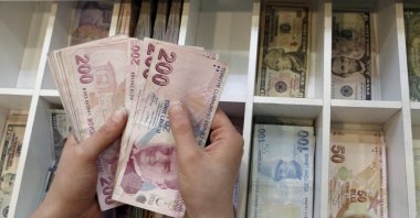 A money changer counts Turkish lira bills at a currency exchange office, central Istanbul, Türkiye, Aug. 21, 2015. (Reuters Photo)