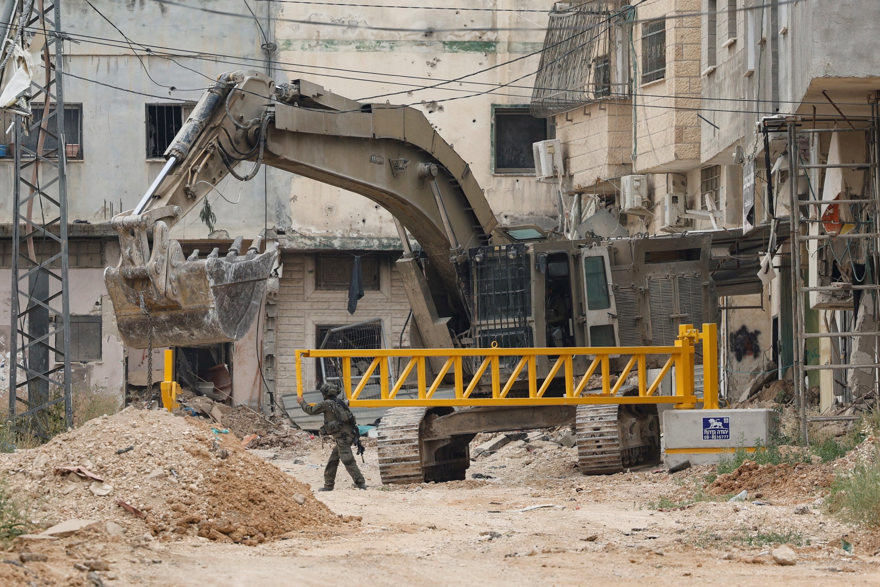 Israeli soldiers install an iron gate at the entrance to Jenin camp, during a military operation that has been ongoing since January 2025, in the Israeli-occupied West Bank, April 23, 2025 REUTERS/Raneen Sawafta