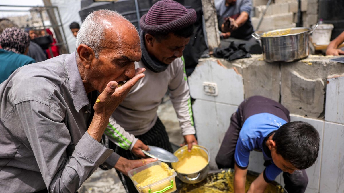 People receive charity meals from a kitchen in Beit Lahia in the northern Gaza Strip, Palestine, April 24, 2025. (AFP Photo)