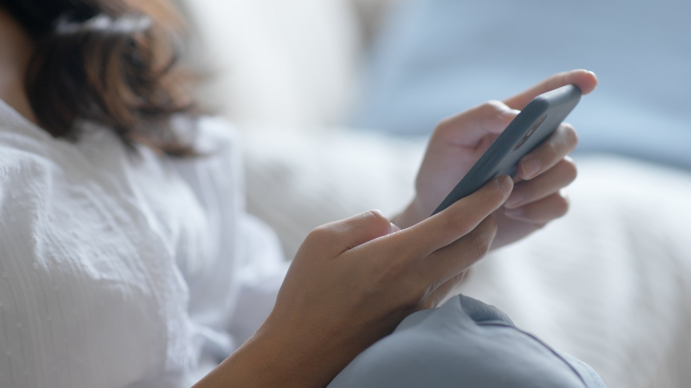 A woman checks an earthquake alert on her smartphone at home. (Shutterstock Photo) 