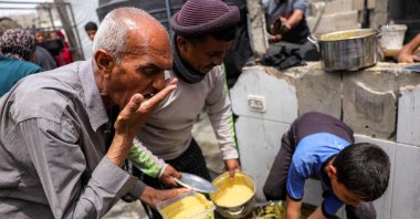 People receive charity meals from a kitchen in Beit Lahia in the northern Gaza Strip, Palestine, April 24, 2025. (AFP Photo)