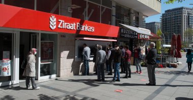 People are seen in front of a branch of Ziraat Bank, Istanbul, Türkiye, April 30, 2020. (Shutterstock Photo)