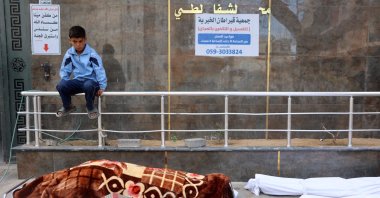 A Palestinian boy sits beside the bodies of the Al-Khour family in the yard of the yard of the Al-Shifa hospital after their house was hit by an Israeli strike in Sabra neighbourhood, Gaza City, the Gaza Strip, April 26, 2025. (AFP Photo)