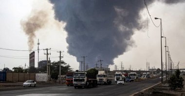 A thick plume of smoke billows as motorists drive their vehicles along a highway near the source of an explosion at the Shahid Rajaee port dock southwest of Bandar Abbas in the Hormozgan province, Iran, April 26, 2025. (AFP Photo)