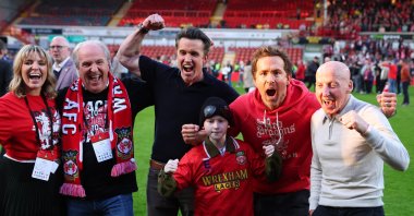 (L-R) Actors and Wrexham owners Rob McElhenney and Ryan Reynolds with former Wrexham footballer Mickey Thomas and Executive Director, Kaleen Allyn with her dad, Manager and Chief Investment Officer of the Allyn&#039;s Family Office, Eric Allyn, celebrate being promoted to the Championship League One - Wrexham v Charlton Athletic - SToK Racecourse, Wrexham, U.K., April 26, 2025. (Reuters Photo)