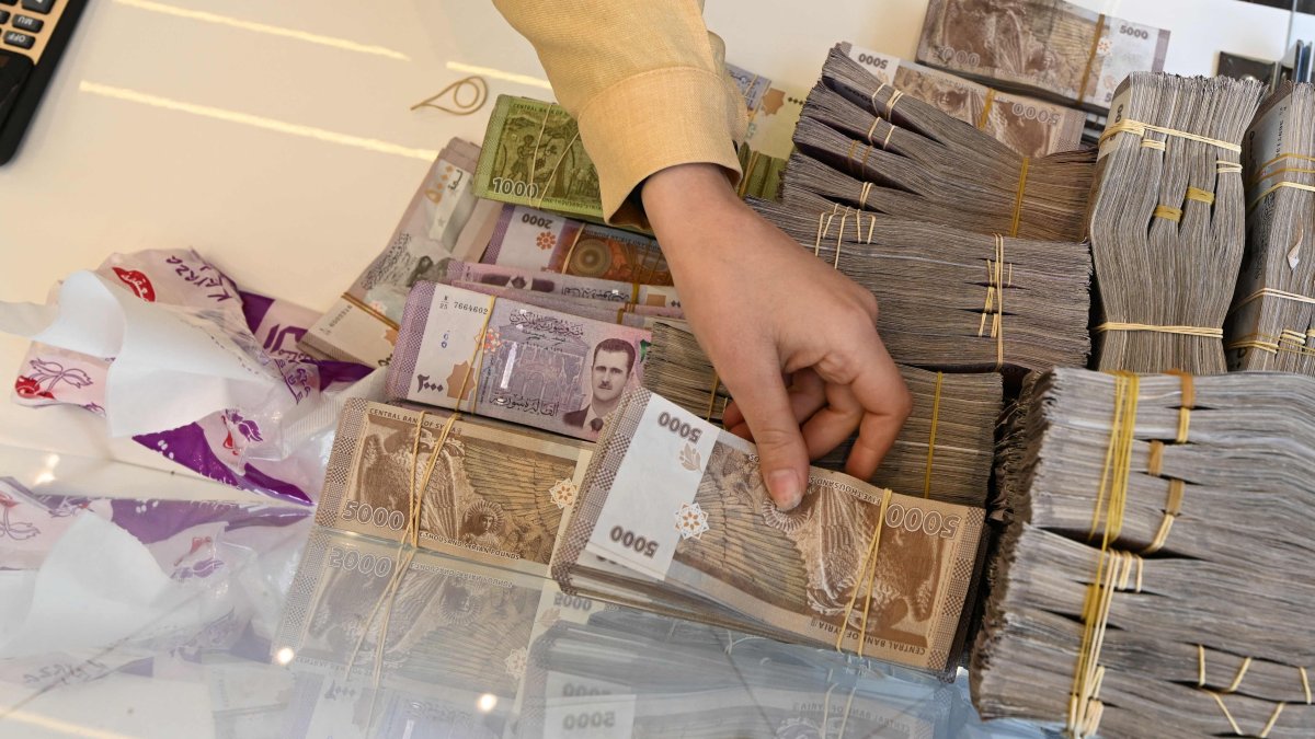 An employee at a currency exchange shop picks up a bill, Damascus, Syria, April 16, 2025. (AFP Photo)