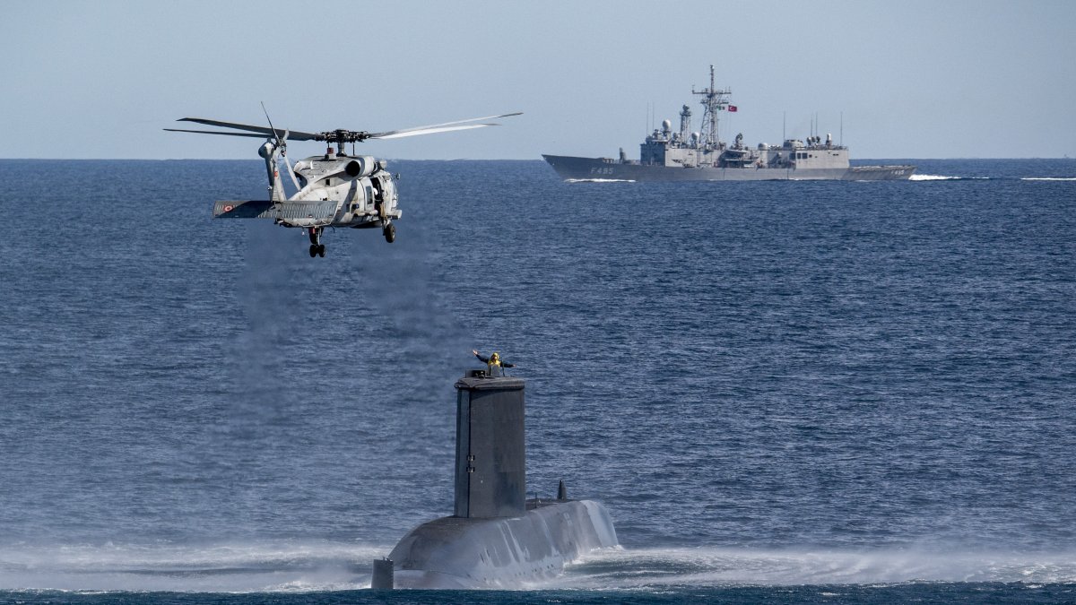 A Turkish navy helicopter, ship and submarine take part in a warfare exercise off the coast of Catania, Sicily, southern Italy, Feb. 26, 2024. (AP Photo)