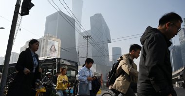 People cross a road on their way to work in Beijing’s central business district, China, April 10, 2025. (AFP Photo)