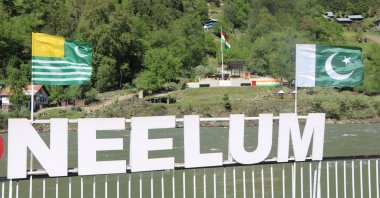Pakistani (R) and Pakistani-administered territory of Azad Kashmir (L) flags are seen in Keran sector, in Neelum Valley, in the Pakistan-administered Kashmir, opposite to the Indian flag (C) in the Indian-administered Kashmir, April 28, 2025. (EPA Photo)
