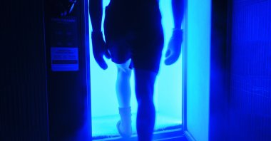 A man entering a cryotherapy cold therapy chamber in a biohacking facility.