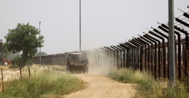 A tractor passes by a field next to the border fencing at the Attari-Wagah border crossing near Amritsar, India, on April 26, 2025. (Reuters Photo) 