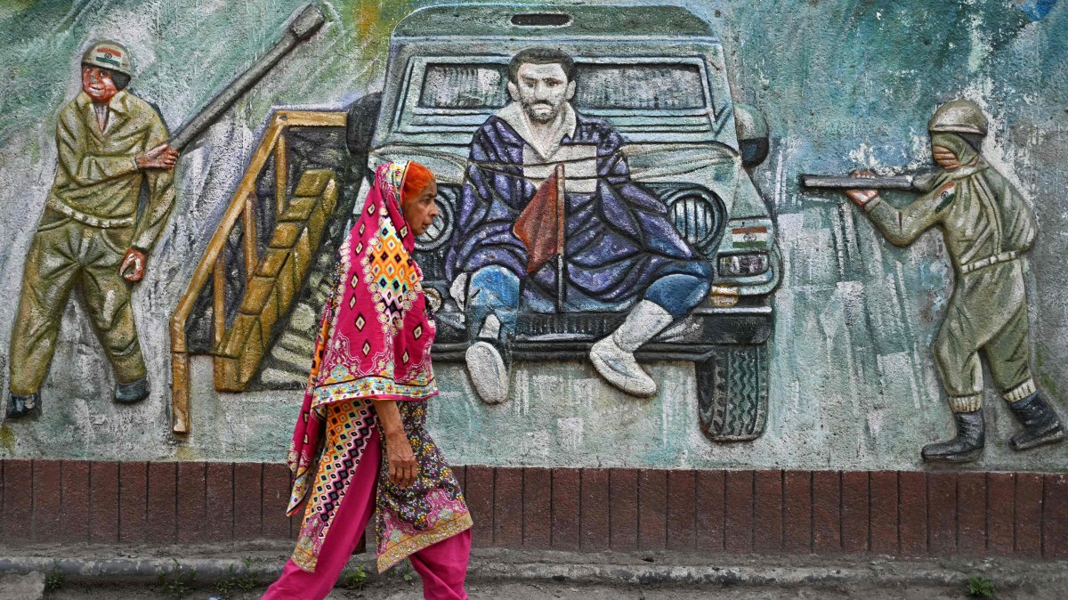 A woman walks past a graffiti along a street in Muzaffarabad, Pakistan-ruled Kashmir, May 1, 2025. (AFP Photo)