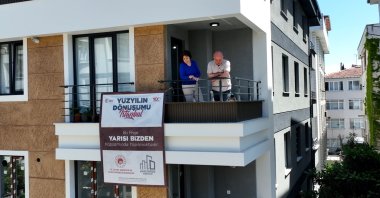 The Öztok family from their newly renovated building's balcony in Avcılar, Istanbul, Türkiye, April 30, 2025. (DHA Photo) 