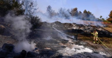 An Israeli firefighter extinguishes a forest fire near Latrun Monastery in central Israel, May 1, 2025. (AFP Photo)