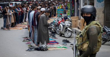 Kashmiri muslims perform Friday prayers on a road as a security personnel stands guard, in Srinagar, May 2, 2025. (Reuters Photo)