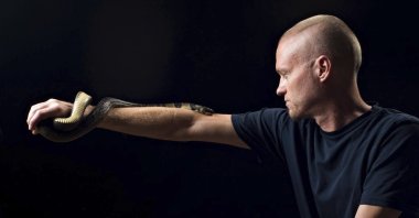 Tim Friede, who is hyper-immune to the venom of various snakes, with a water cobra wrapped around his arm. (AP Photo)