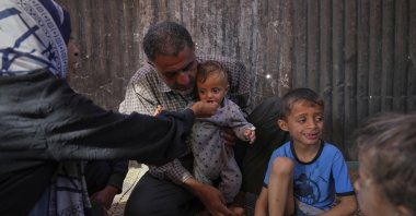 Wedad Abdelaal and her husband Ammar, feed their 9-month-old son, Khaled, in their tent at a camp for displaced Palestinians in Mawasi Khan Younis, Gaza Strip, May 2, 2025. (AP Photo)