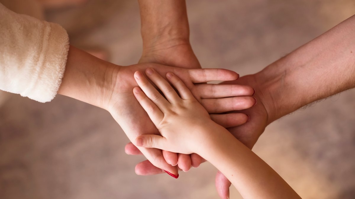 Hands of parents and children joined together, showing family unity. (Shutterstock Photo) 