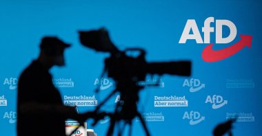 A cameraman silhouettes against a wall with the AfD logo during a congress of Germany&#039;s far-right Alternative for Germany (AfD) party in Dresden, Eastern Germany, April 11, 2021. (AFP Photo)