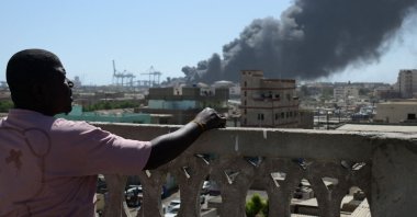 A man watches as smoke billows after a drone strike on the port of Port Sudan, Sudan, May 6, 2025. (AFP Photo)