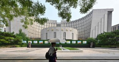 A woman walks past the headquarters of the People’s Bank of China (PBOC), the country’s central bank, Beijing, China, July 9, 2024. (AFP Photo)