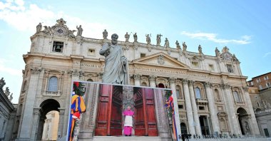 Faithful watch a giant screen displaying images of Diego Giovanni Ravelli,  Master of Pontifical Liturgical Celebrations, closing the doors of the Sistine Chapel as the conclave to elect a new Pope starts, at St Peter&#039;s Square, The Vatican, May 7, 2025. (AFP Photo)