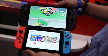 An attendee compares the Nintendo Switch 2 (top) to the original version during the Nintendo Switch 2 Experience at the ExCeL London international exhibition and convention centre, London, U.K., April 11, 2025. (Reuters Photo)