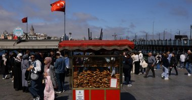 People walk as simit, a traditional Turkish bagel, are displayed at a stall for sale at Eminönü district, Istanbul, Türkiye, April 23, 2025. (Reuters Photo)