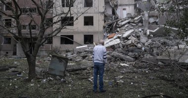 A local man waits for Ukrainian rescuers and municipal services workers to find his mother under the rubble, during the dismantling of a residential building destroyed by a high-explosive aerial bomb amid the Russian invasion, in the frontline city of Kostyantynivka, Donetsk region, eastern Ukraine, May 8, 2025. (EPA Photo)