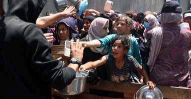 Palestinians jostle for position to get a hot meal, in front of a distribution point at the Nuseirat refugee camp in the central Gaza Strip, May 10, 2025. (AFP Photo)