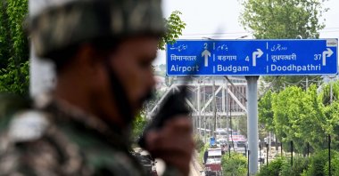 An Indian paramilitary personnel uses a handheld transceiver as he stands guard along a street leading to the international airport in Srinagar, India, May 10, 2025. (AFP Photo)