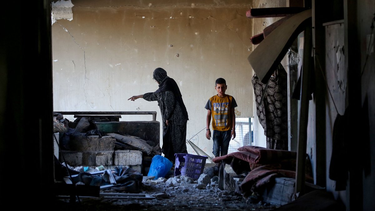 A Palestinian woman and a child check a room at a UNRWA school housing displaced people, following an Israeli strike in the Bureij, Gaza Strip, Palestine, May 7, 2025. (AFP Photo)