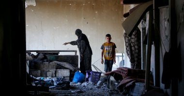 A Palestinian woman and a child check a room at a UNRWA school housing displaced people, following an Israeli strike in the Bureij, Gaza Strip, Palestine, May 7, 2025. (AFP Photo)