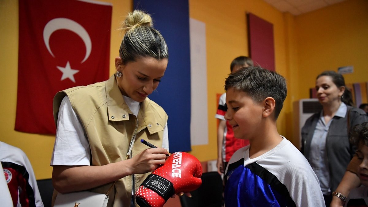 National boxer Hatice Akbaş (L) shares her experiences with Yeşilyurt Municipality Kickboxing Team athletes and signs boxing gloves during an event at the Yakınca Life and Sports Center, Malatya, Türkiye, May 2, 2025. (AA Photo)