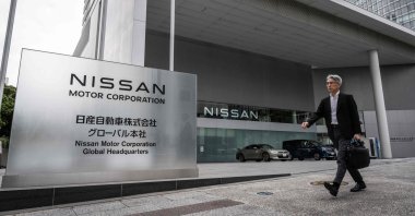 A man walks past the head office of Japanese automaker Nissan Motor, Yokohama, Kanagawa prefecture, Japan, May 9, 2024. (AFP Photo)