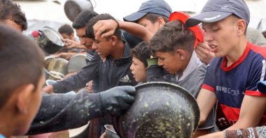 Palestinian youths shove to get a ration of hot food from a charity kitchen set up in Gaza City, central Gaza Strip, Palestine, May 12, 2025. (AFP Photo)