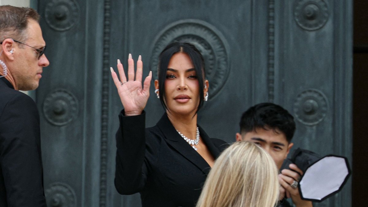 U.S. celebrity Kim Kardashian (C) waves as she arrives at the Assize Court for the trial during which she will testify over the 2016 robbery that saw her relieved of millions of dollars&#039; worth of jewelry at gunpoint, Paris, France, May 13, 2025. (AFP Photo)