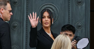 U.S. celebrity Kim Kardashian (C) waves as she arrives at the Assize Court for the trial during which she will testify over the 2016 robbery that saw her relieved of millions of dollars&#039; worth of jewelry at gunpoint, Paris, France, May 13, 2025. (AFP Photo)