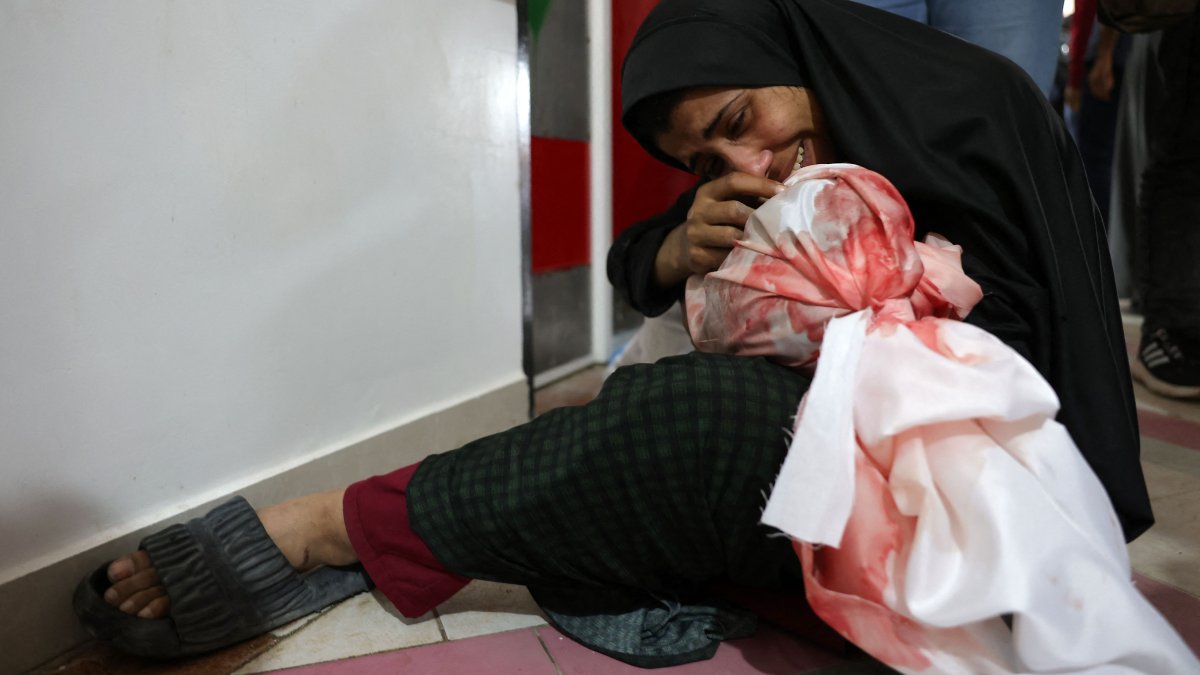 A Palestinian woman cries as she holds the body of a child killed in Israeli strikes on Jabalia, northern Gaza Strip, Palestine, May 14, 2025. (AFP Photo)